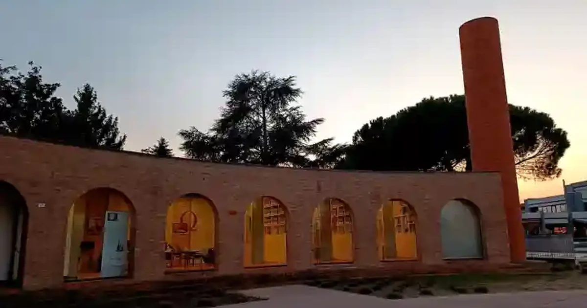 Edificio con facciata in mattoni e archi vetrati al tramonto — contesto urbano nella cintura padovana (Vigonza e Rubano)